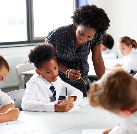 A private school teacher working with students in a classroom