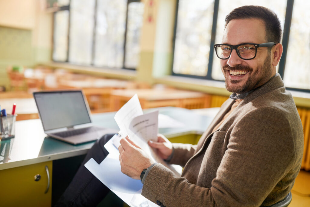 Smiling teacher working on a unified school software platform