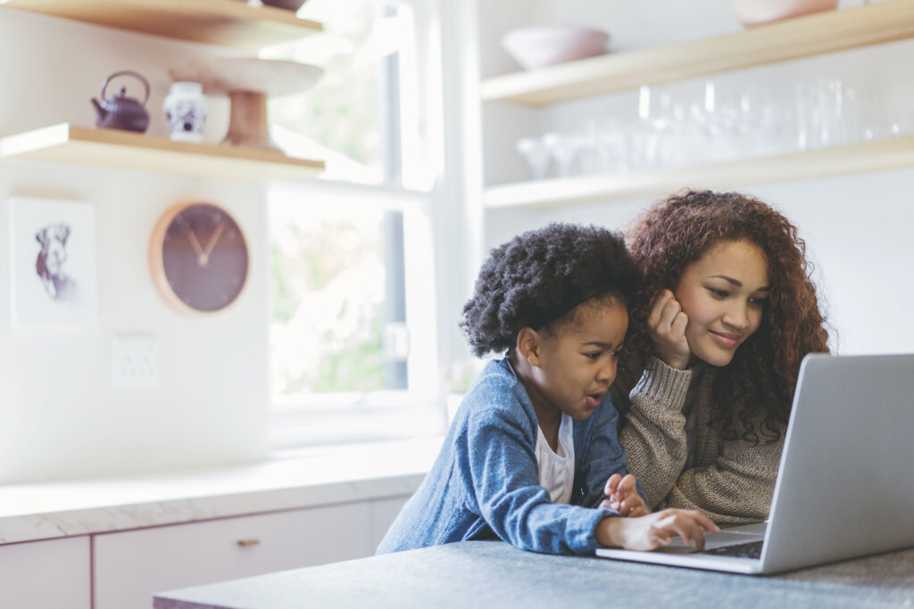 Daughter and Mother using computer to re-enroll for private school